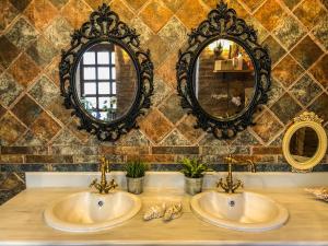 two sinks in a bathroom with two mirrors at Lykos Mansion in Kápsas