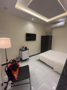 1 dormitorio con 1 cama y TV en la pared en استديو سرير ماستر ودخول ذاتي بحي الملقا, en Riad