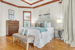 a white bedroom with a bed and a chair at Villa Tuscana in Destin
