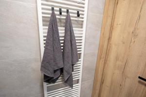 2 toallas colgando de un perchero en el baño en ALURE RESIDENCES 5 & 24h self check-in with private parking, en Banská Bystrica