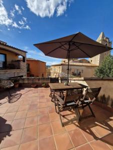 - une table et des chaises avec un parasol sur la terrasse dans l'établissement Can Bruguera de Fonteta, à Fonteta