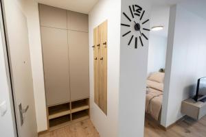 une chambre avec une horloge sur le mur et une chambre dans l'établissement ALURE RESIDENCES 5 & 24h self check-in with private parking, à Banská Bystrica