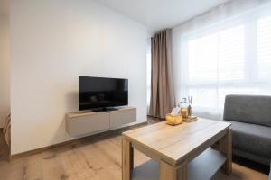 a living room with a tv and a table at ALURE RESIDENCES 5 & 24h self check-in with private parking in Banská Bystrica