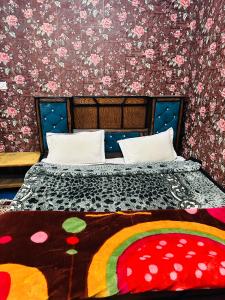 a bedroom with a bed with a floral wall at HOTEL MERLIN PALACE in Srinagar