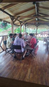 un grupo de personas sentadas alrededor de una mesa en Hotel Liah's en Tortuguero