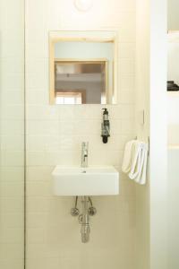 a white bathroom with a sink and a mirror at Vinum Apartamentos 1890 in Coimbra +25 photos