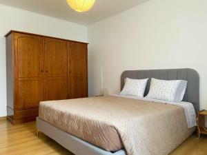 1 dormitorio con 1 cama grande y armario de madera en São Roque Apartment, en São Roque