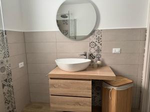 een badkamer met een witte wastafel en een spiegel bij Za Nedda Home in Fiumefreddo di Sicilia
