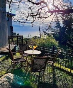 a patio with a table and chairs and a fence at Incredible Views Beautiful 2-Bedroom Suite in Victoria
