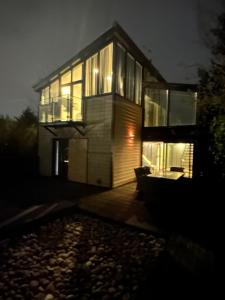 ein Haus in der Nacht mit vielen Fenstern in der Unterkunft West View 3 Bedroom Villa With Hot Tub in Heeley