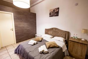 um quarto com uma cama grande e toalhas em Promenade B&B em Catânia