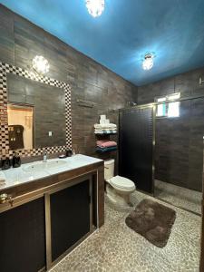 a bathroom with a sink and a toilet and a mirror at Hacienda Cúpulas Blue Private Residence Club in Cozumel