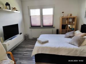 1 dormitorio con 1 cama y TV de pantalla plana en Airport Room en Düsseldorf
