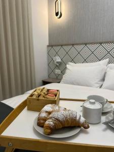 a table with a tray of bread on a bed at Minerva Suite in St. Paul's Bay