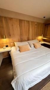 a large white bed in a room with wooden walls at Hotel Boutique Miranda in Oaxaca City