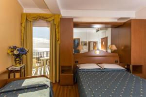a bedroom with a large bed and a balcony at Hotel Mondial in Lido di Jesolo
