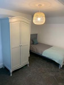 1 dormitorio con 1 cama y armario blanco en Cosy 2 bedroom Cottage in Saint Dogmaels- river views, en Cardigan