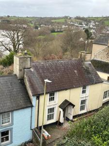 an old white and blue house with an attic at Cosy 2 bedroom Cottage in Saint Dogmaels- river views in Cardigan