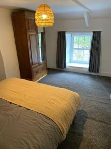 Un dormitorio con una cama amarilla y una ventana en Cosy 2 bedroom Cottage in Saint Dogmaels- river views, en Cardigan