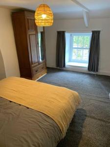 a bedroom with a yellow bed and a window at Bryndegwel in Saint Dogmaels, cardigan- river views, Free parking in Cardigan +16 photos