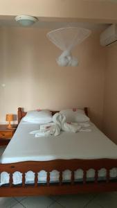 a bed with white sheets and a fan on it at HAVRE DE PAIX in Le Robert