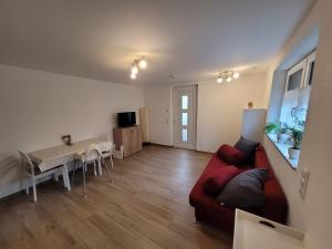 uma sala de estar com um sofá vermelho e uma mesa em Wyhler Kunterbunt em Wyhl