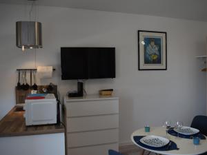 a living room with a flat screen tv on a wall at Studio ★★★, Climatisé, Wifi, Proche Thermes et Commerces - FR-1-503-140 in Balaruc-les-Bains