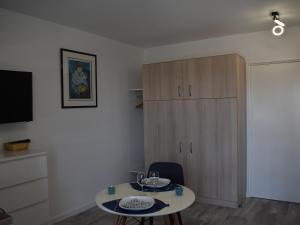 a living room with a table and a cabinet at Studio ★★★, Climatisé, Wifi, Proche Thermes et Commerces - FR-1-503-140 in Balaruc-les-Bains
