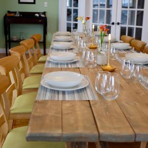 a long wooden table with plates and glasses on it at The Bread and Cheese Country Inn in Bay Bulls