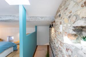 a bedroom with a stone wall and a blue door at L'alouette - Duplex Calme, Climatisé, Hyper-centre in Castres +23 photos