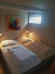 two twin beds in a bedroom with a window at Hyttan in Åkirkeby