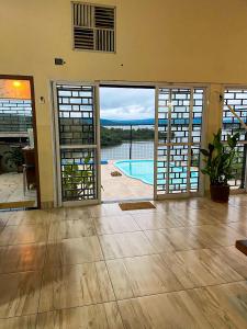 uma sala de estar com portas que se abrem para uma piscina em Paraíso Panorâmico Beira do Lago em Caldas Novas