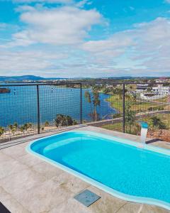 uma piscina com vista para a água em Paraíso Panorâmico Beira do Lago em Caldas Novas