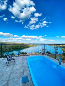 uma piscina num pátio com vista para a água em Paraíso Panorâmico Beira do Lago em Caldas Novas