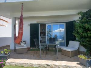 a patio with a table and chairs and an umbrella at Ericeira Su Villa`s in Ericeira
