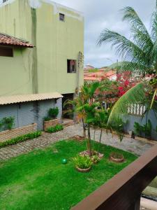 un jardin avec des palmiers et un bâtiment dans l'établissement Quarto Praia do Frances, à Marechal Deodoro