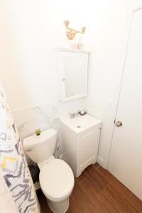 ein weißes Bad mit einem WC und einem Waschbecken in der Unterkunft Deluxe Studio Apt Close to NYC in Union City