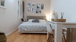 a white bedroom with a bed and a desk at Apartment Mana in Mostar