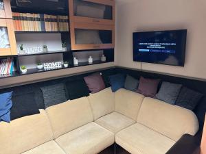 a living room with a couch and a tv at Romantic apartman in Szeged