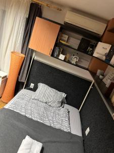 a bedroom with a bed and a book shelf at Romantic apartman in Szeged