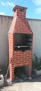 um forno de tijolos ao ar livre com uma espátula em Tiny House Novas Palmeiras em Florianópolis