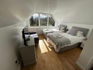 1 dormitorio con 2 camas y TV. en Borrowdale View en Keswick
