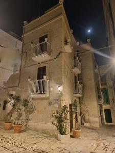 a building with potted plants in front of it at night at B&B DIMORA PALMIERI in Monopoli