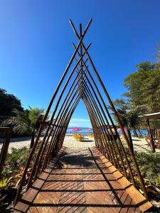 a wooden bridge on a beach with the ocean at Pousada Cantinho da Praia in Paraty