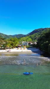 a group of people in the water at a beach at Pousada Cantinho da Praia in Paraty