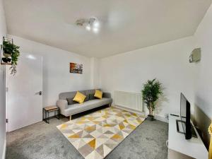 ein Wohnzimmer mit einem Sofa und einem Teppich in der Unterkunft Modern Cosy 1 Bed Ilford Home - Free Parking in Ilford