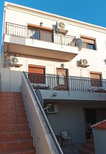 a building with stairs leading up to a balcony at Vaikouzis Houses in Samothráki