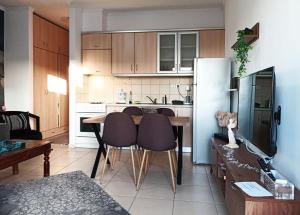 a kitchen with a table and chairs and a refrigerator at Vaikouzis Houses in Samothraki