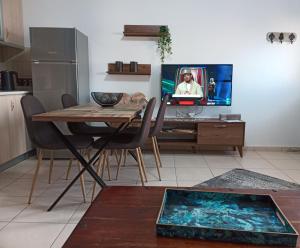 a living room with a table and a tv and a kitchen at Vaikouzis Houses in Samothraki