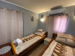 - 2 lits jumeaux dans une chambre avec fenêtre dans l'établissement Babér Apartmanház Balatonakarattya, à Balatonkenese